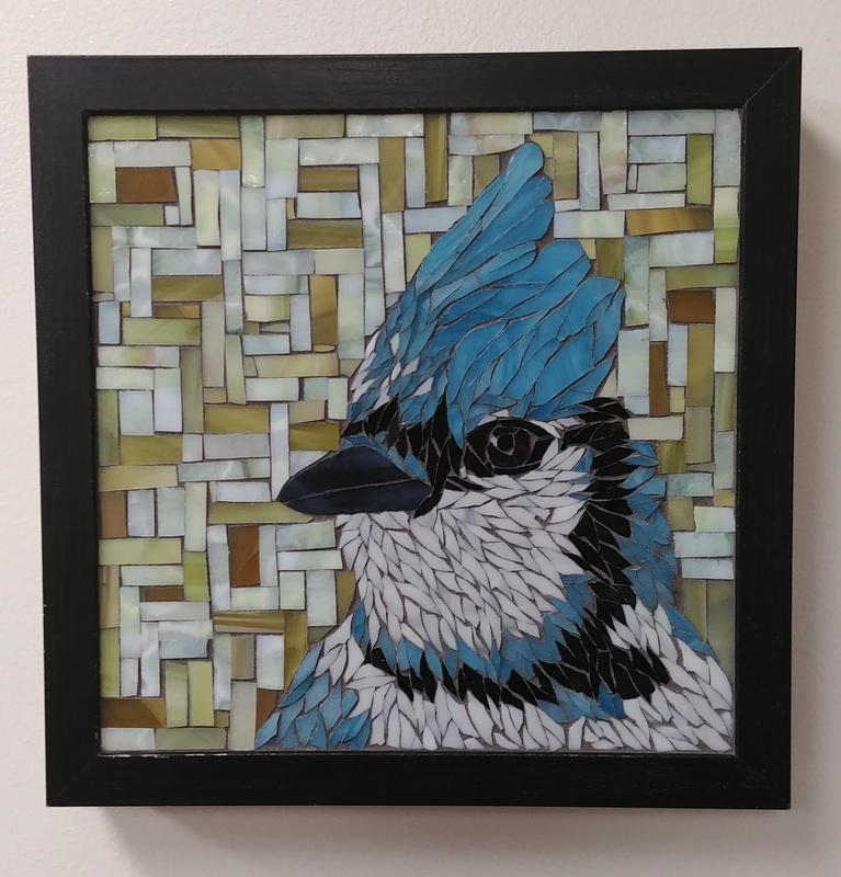 Stained glass mosaic portrait of a blue jay bird with a rectangular geometric lime green pattern background.