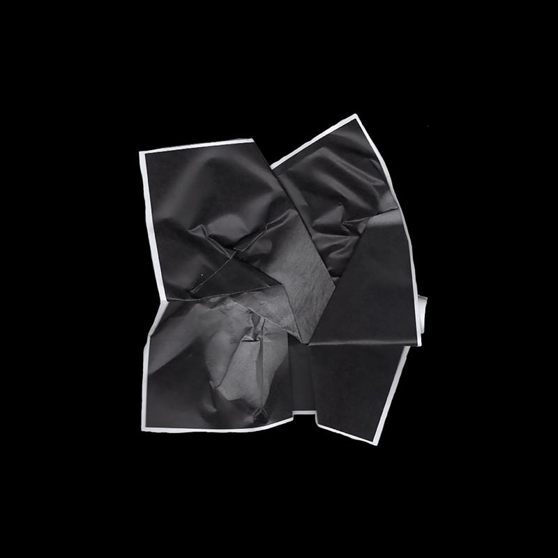 A black and white photocopy of an arm and hand crumpled up.