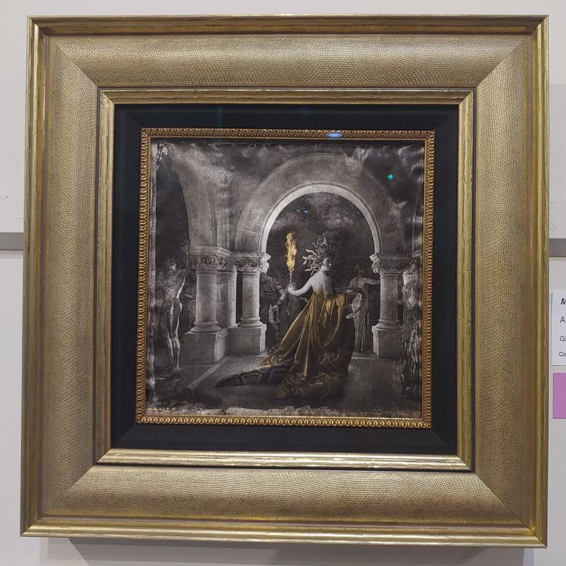 A black and white photograph of Medusa and her statues inside her castle. Gold and silver foil accents.