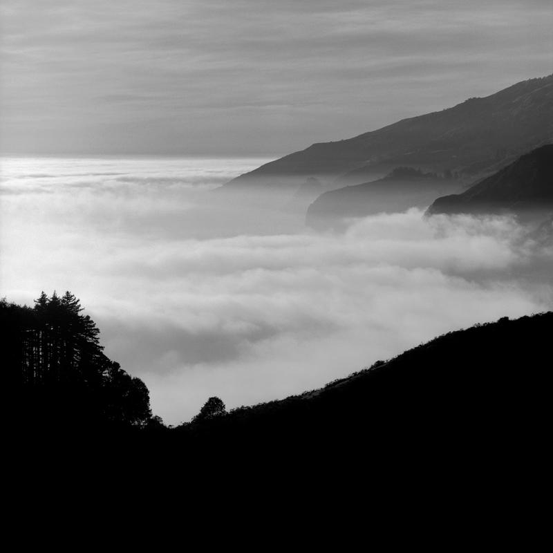 Black and white photograph of a highway obscured by fog in Bug Sur, California