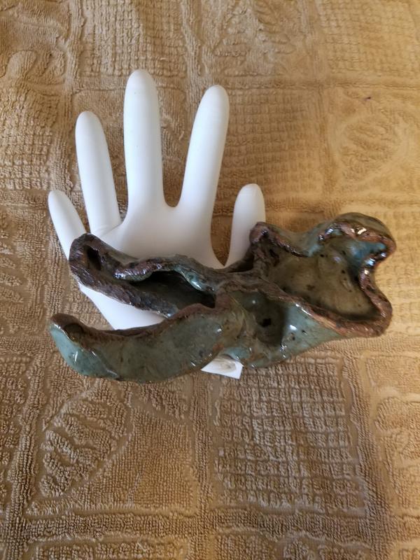 Stylized hand with reclining figure