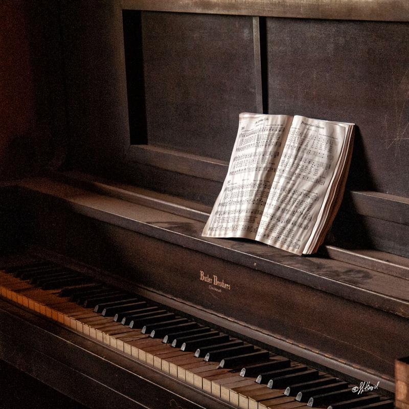 A photo of a dusty piano with music notes.