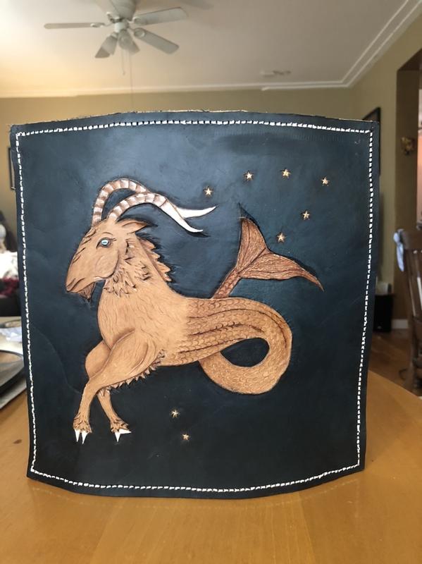 Capricorn Goat hand tooled and textured in leather with constellation in a blue black sky.