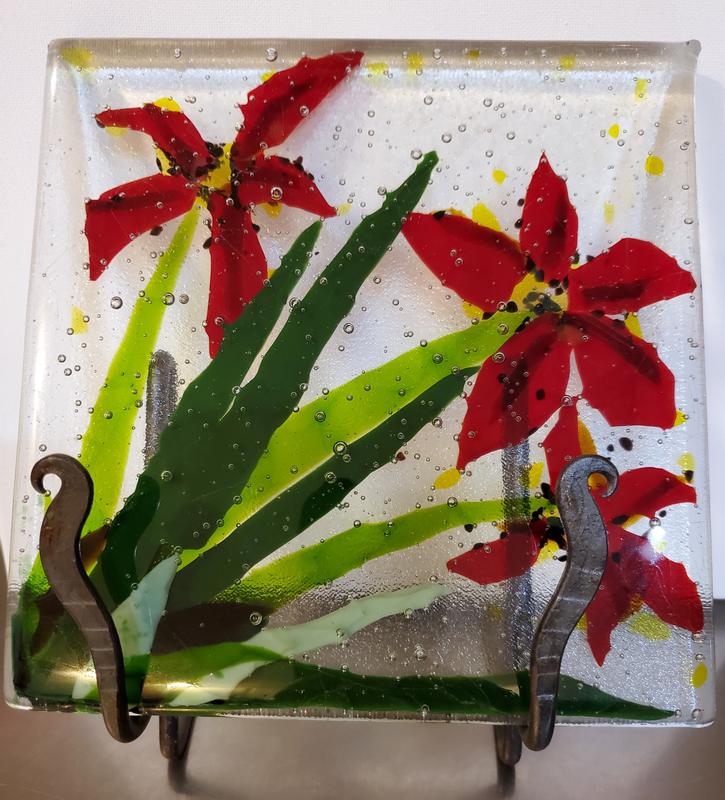 Red Flowers bursting out of green spiked foliage.